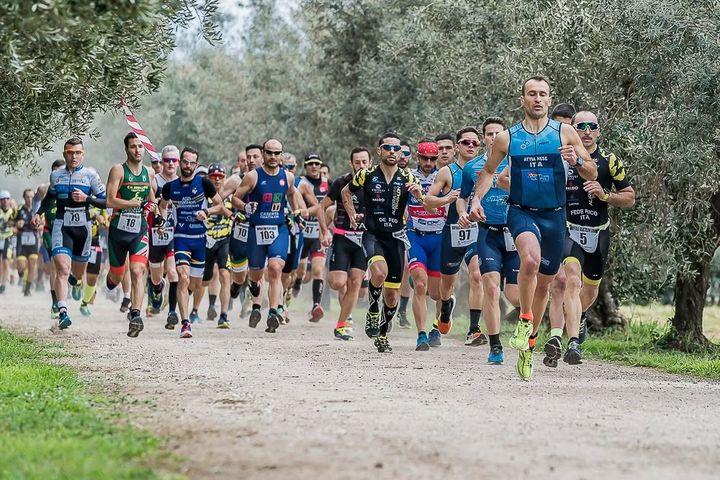 Gruppo di atleti di corsa tra gli ulivi al Buffalo Duathlon Cross