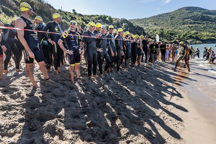 Atleti in muta allineati sulla spiaggia prima della partenza